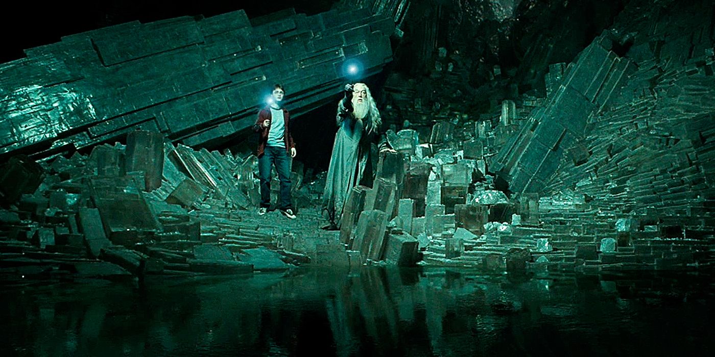 Harry and Dumbledore holding up their lit wands in a cave in Harry Potter. 