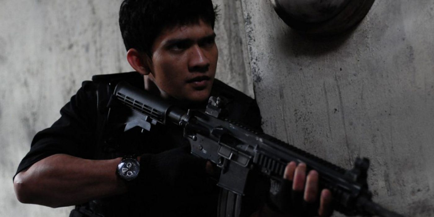 Iko Uwais armed with an assault rifle in The Raid