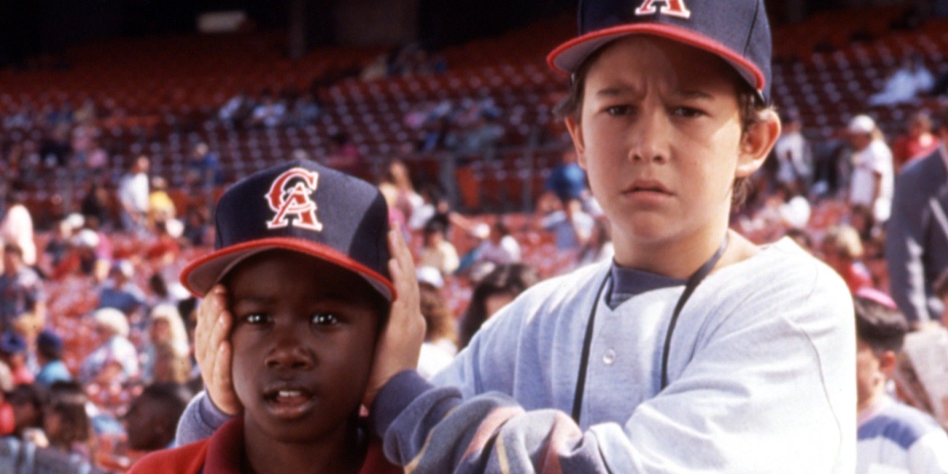A kid with his hands over another kid's ears in Angels in the Outfield 