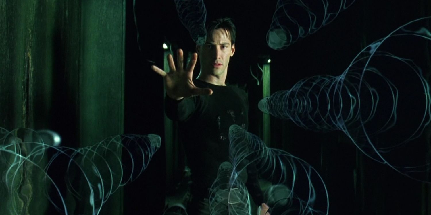 Keanu Reeves as Neo holding up his hand to stop bullets in mid-air in the finale of The Matrix