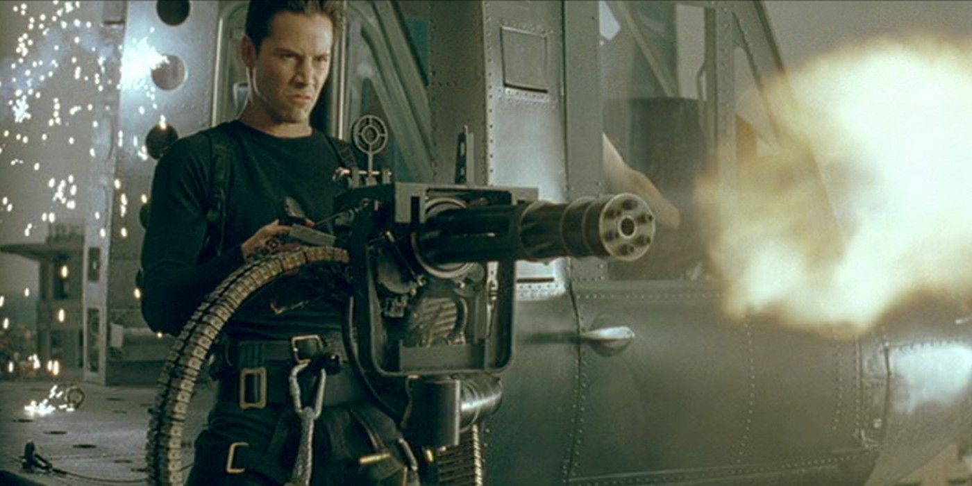 Keanu Reeves as Neo fires rounds from a mounted machine gun inside a helicopter positioned in front of a building in an attempt to save Morpheus' life in The Matrix