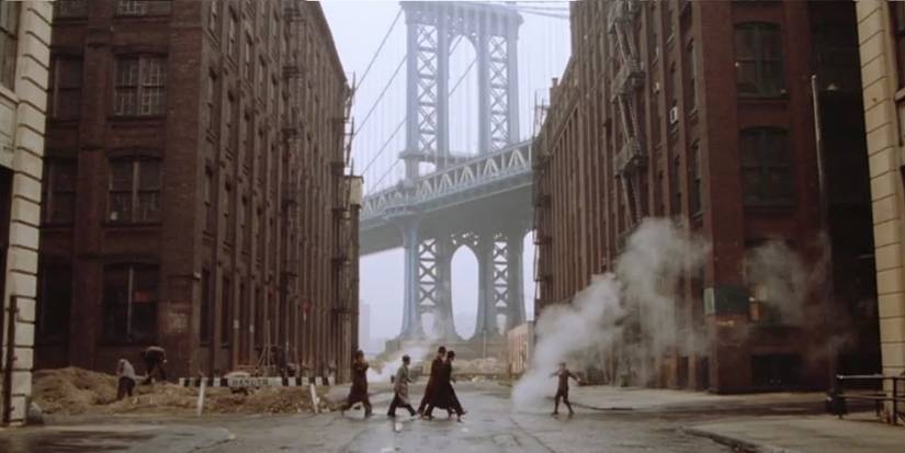 Iconic shot from Once Upon a Time in America of characters walking with the Manhattan Bridge behind them.
