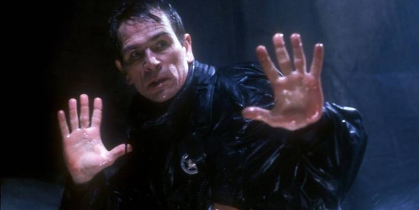 Tommy Lee Jones holding his hands up in The Fugitive