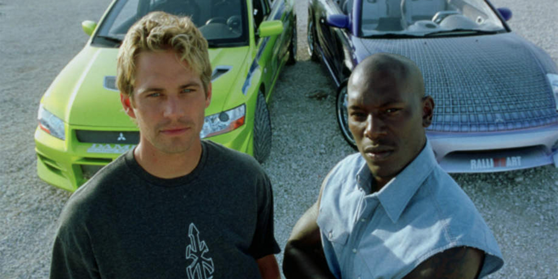 Brian e Roman posam na frente de dois carros em 2 Fast 2 Furious