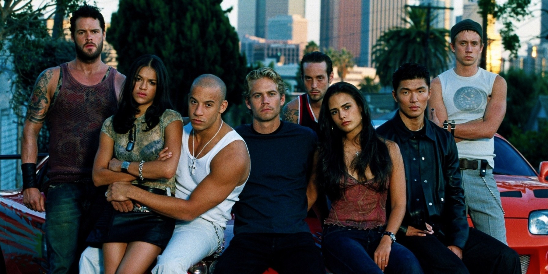 The Fast and the Furious cast sitting together in front of the LA skyline