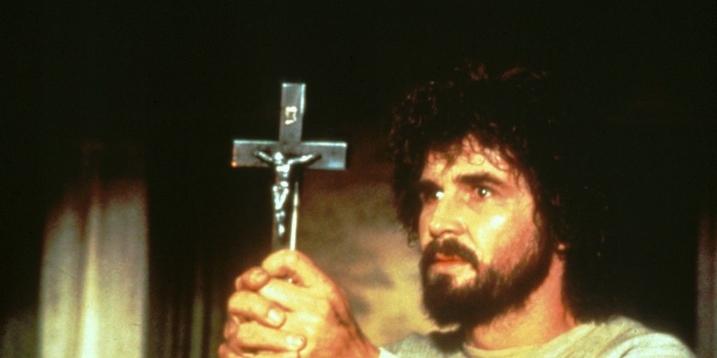 A man holding a crucifix in The Amityville Horror