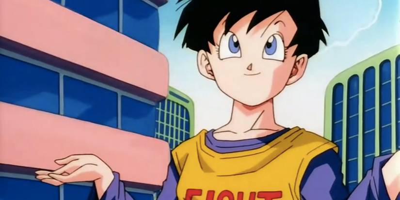 Videl dari Dragon Ball Fusion Reborn mengangkat bahu dan tersenyum di tengah kota.