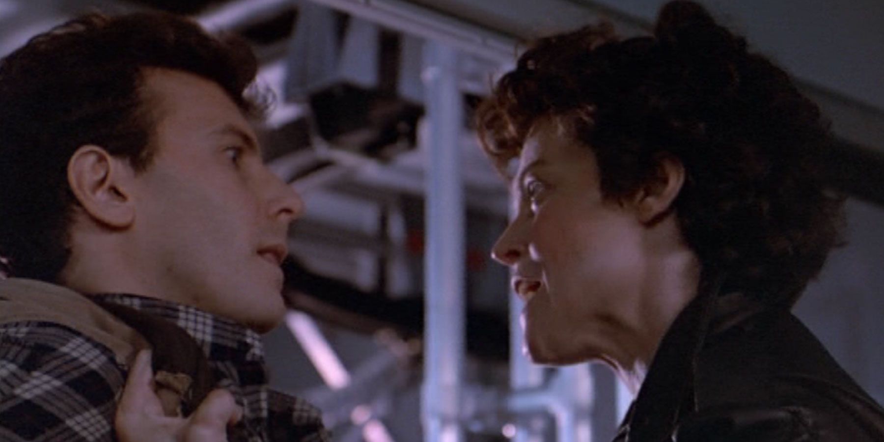 Ripley segura Burke com as mãos em Aliens.