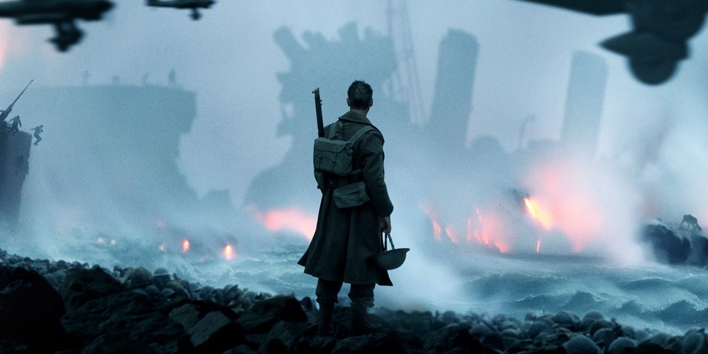 Soldier looking at ships on fire in the sea in Dunkirk