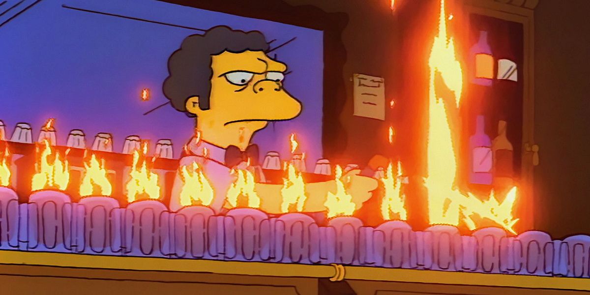 Moe standing behind the bar with a row of Flaming Moes