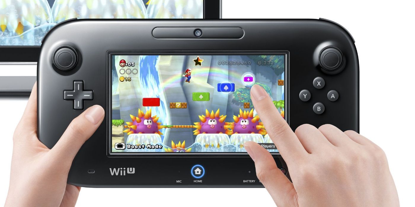 Mains tenant le Wii U GamePad et jouant au jeu Mario. 