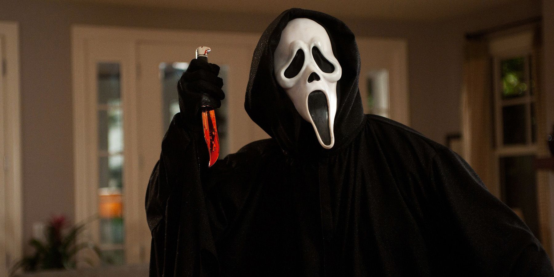 Ghostface sosteniendo un cuchillo ensangrentado en Scream 1996