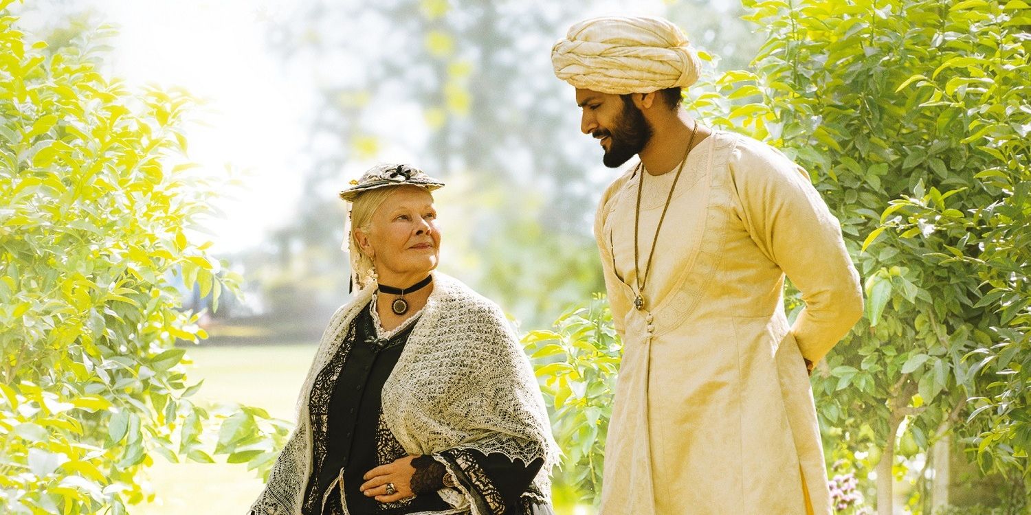 Victoria and Abdul walk together in a garden in Victoria and Abdul.