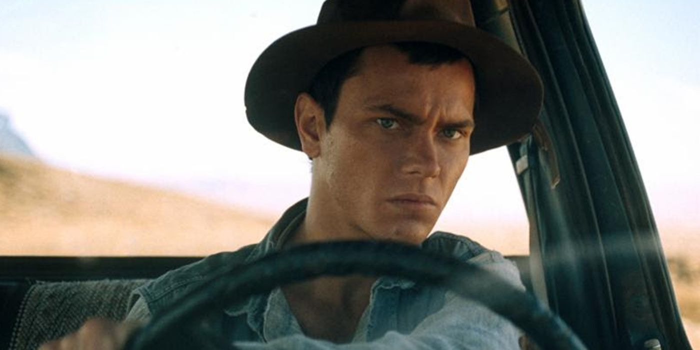 An image of River Phoenix looking threatening while sitting behind a car in Dark Blood