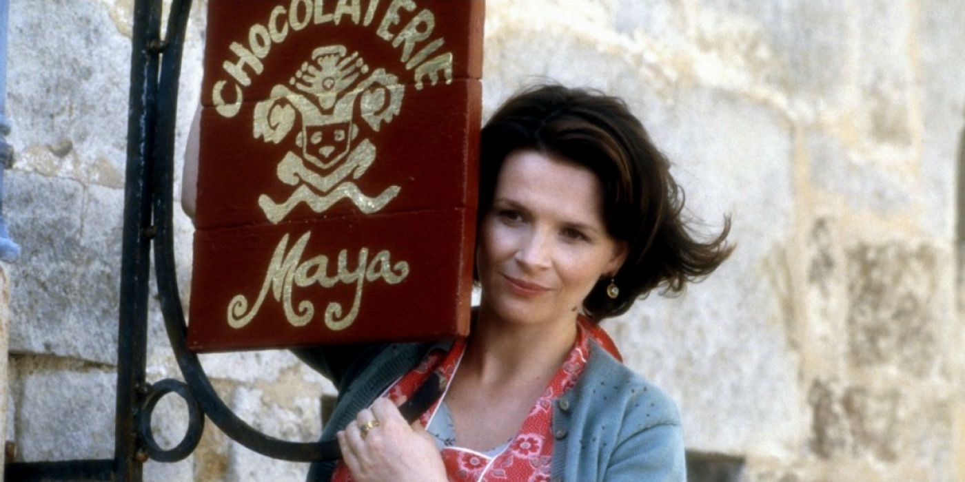 Vianne leaning on a sign and smiling in Chocolat