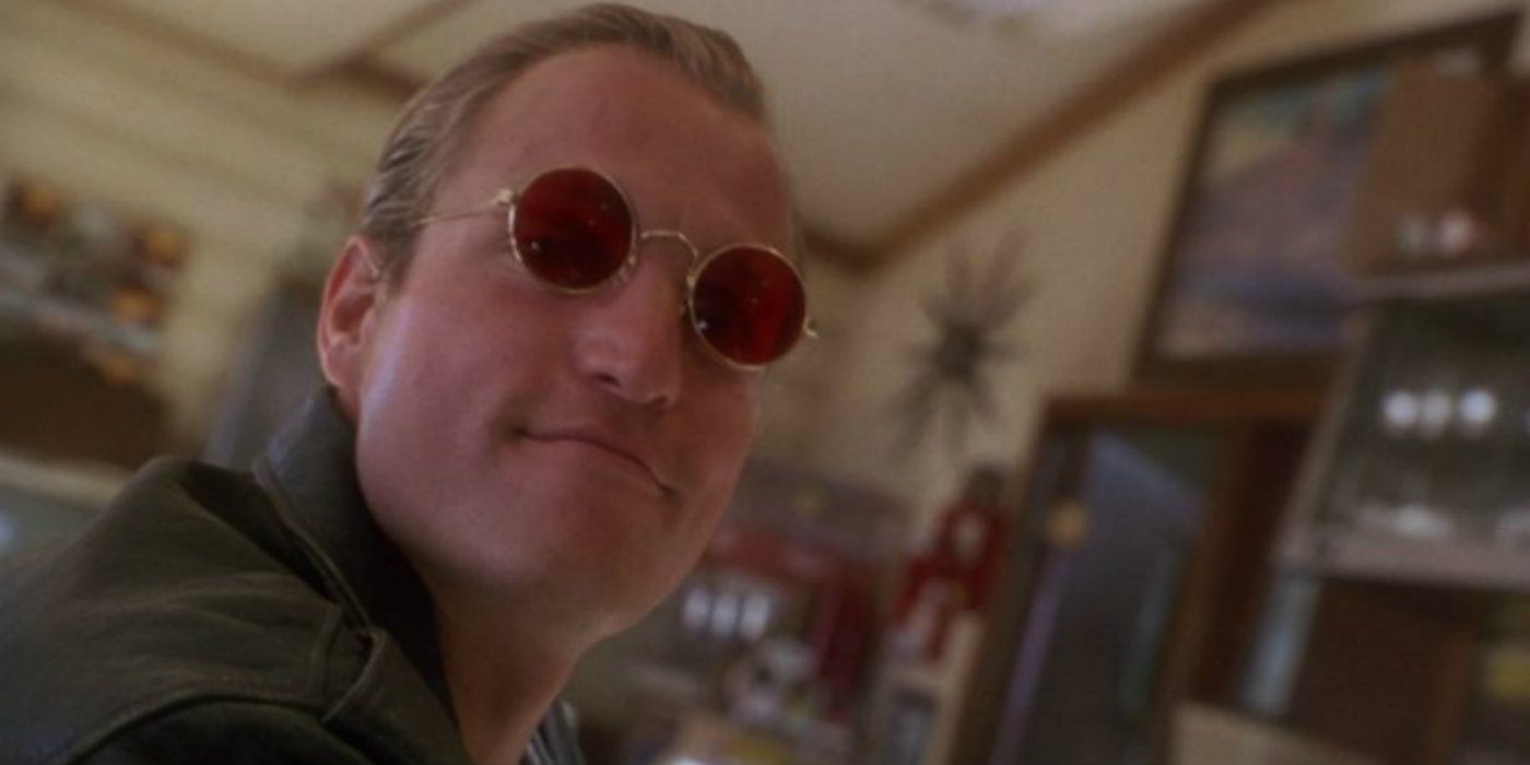 Woody Harrelson sitting in a diner smiling in Natural Born Killers