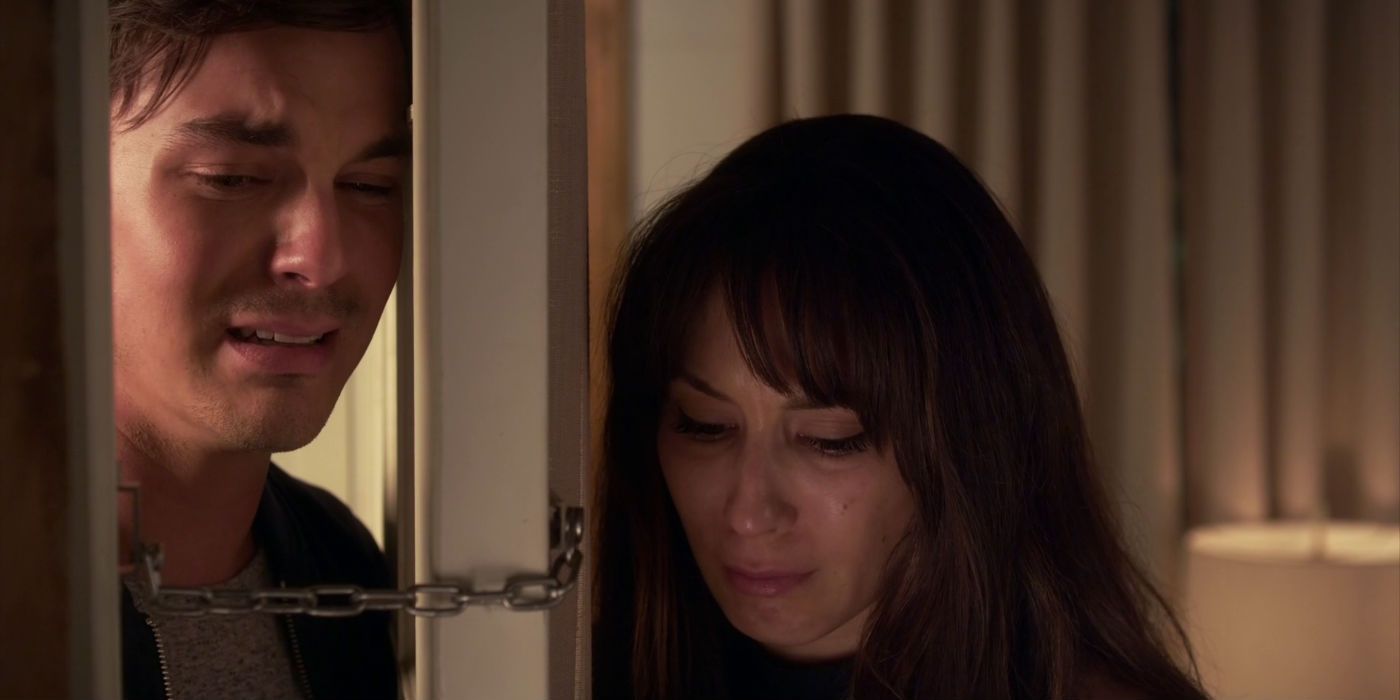 Caleb and Spencer crying on sides of a door on Pretty Little Liars