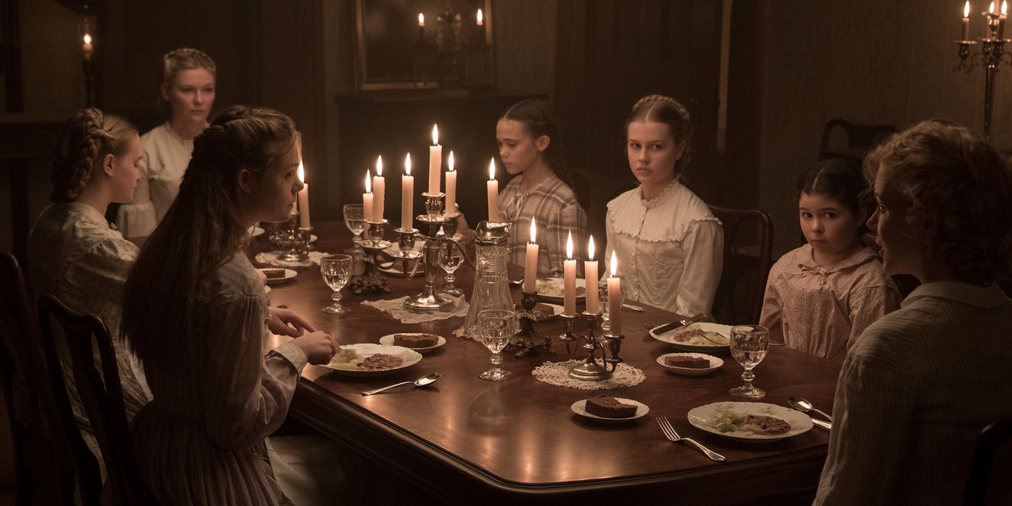 Miss Martha and her family sit around a candle lit dinner table in The Beguiled