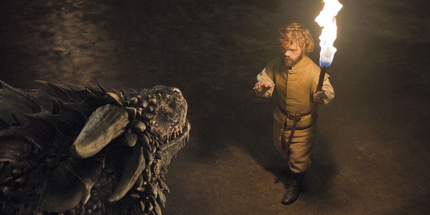 Tyrion Lannister approaches a dragon while carrying a torch in Game of Thrones