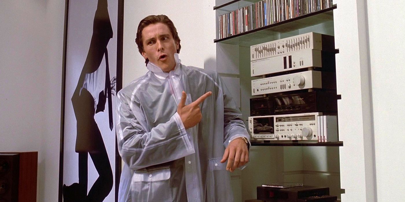 Patrick Bateman in American Psycho wearing a sheer rain slicker and pointing towards his stereo.