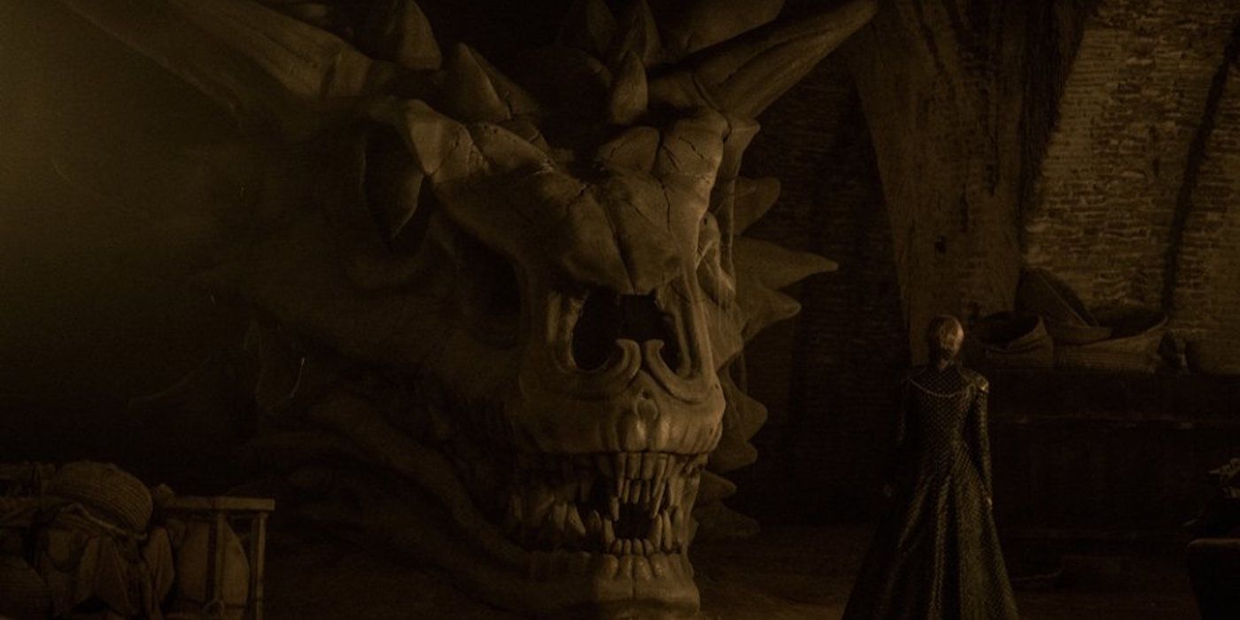 Cersei Lannister standing next to the skull of Balerion the Black Dread.