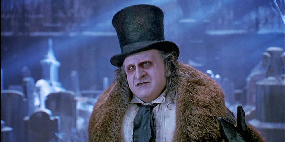 The Penguin stands in his top hat and coat in Batman Returns