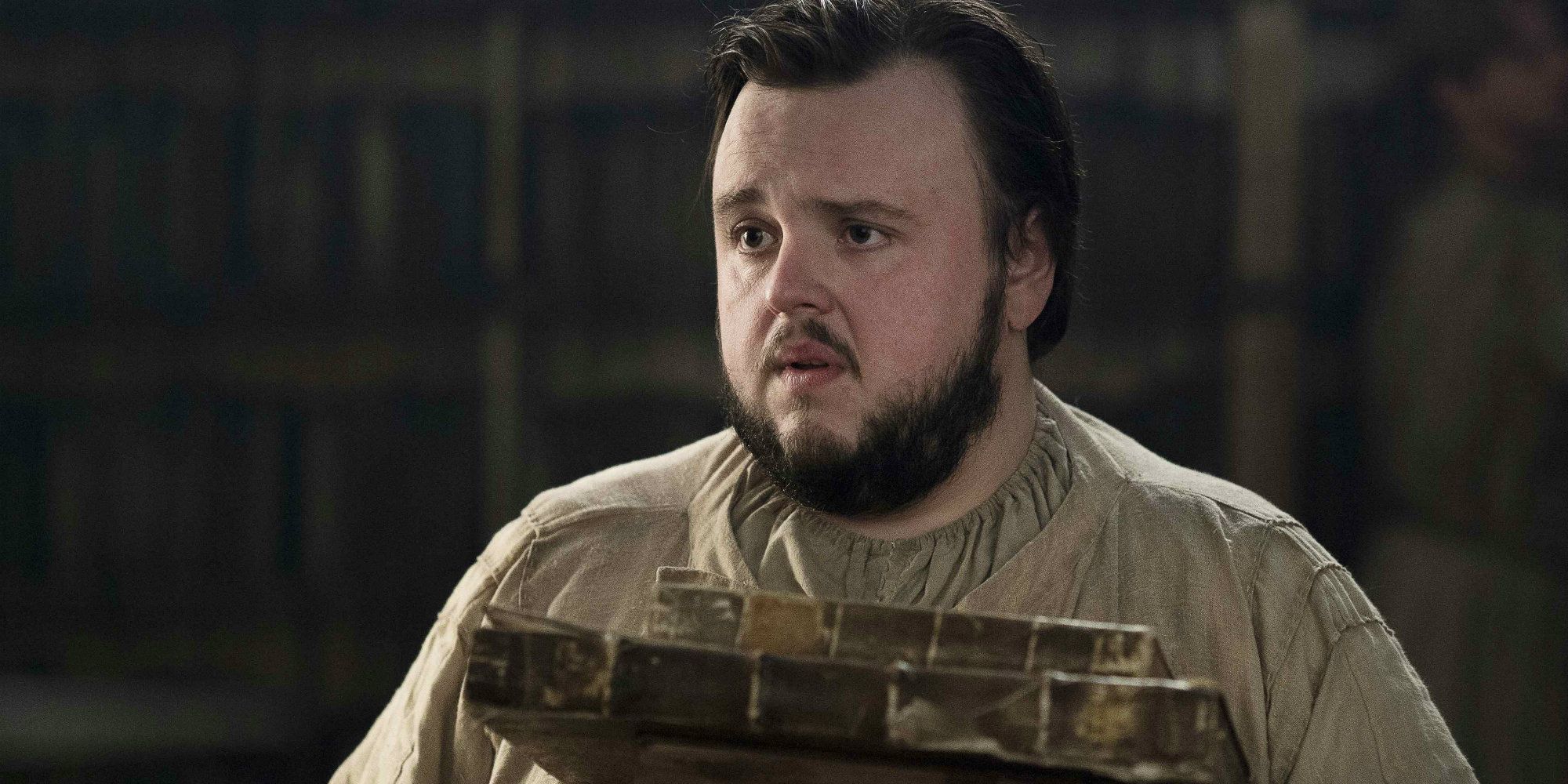 Sam holding books at the Citadel in Game of Thrones