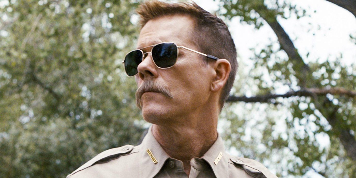 Kevin Bacon stands in the forest with sunglasses in Cop Car
