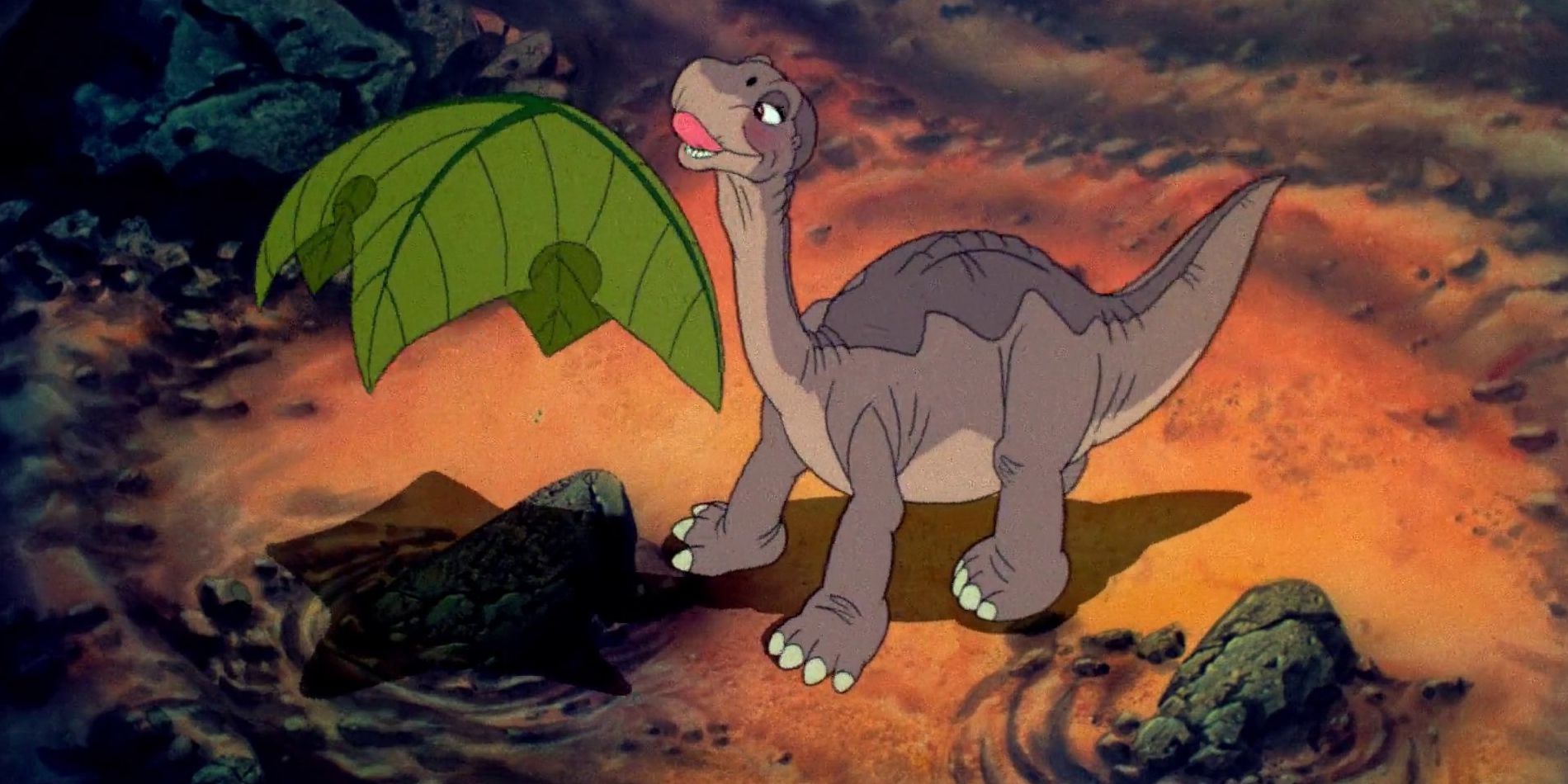 Little Foot looking up at a leaf in The Land Before Time