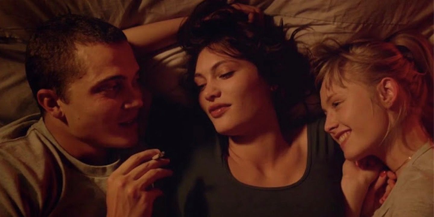 Karl Glusman, Aomi Muyock, and Klara Kristin lying in bed in Love