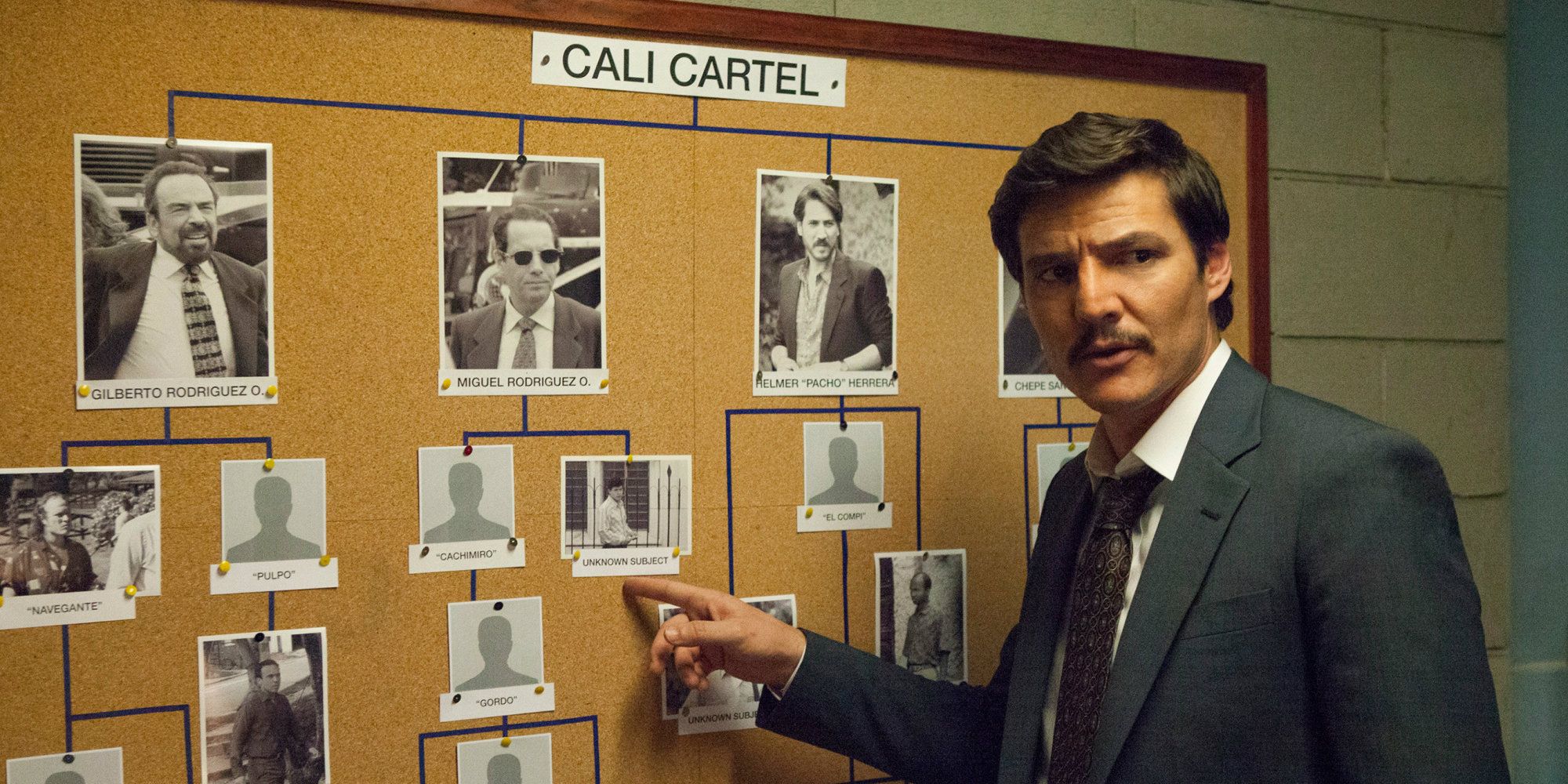 Pedro Pascal standing at a board in Narcos