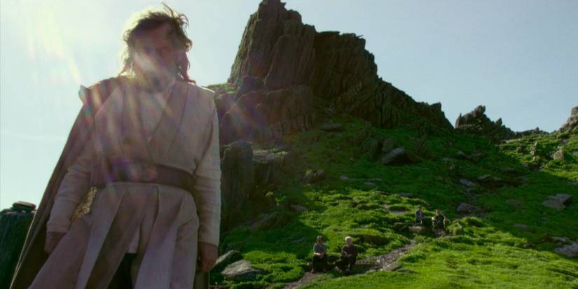 Mark Hamill as Luke Skywalker stands in front of the island on Ahch-To