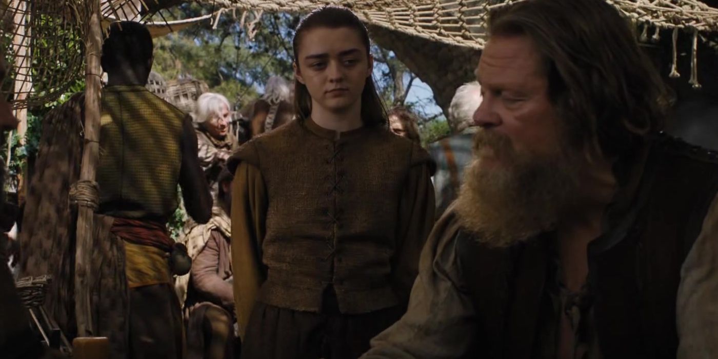 Arya Stark parecendo orgulhosa enquanto conversa com um homem em Bravos em Game of Thrones