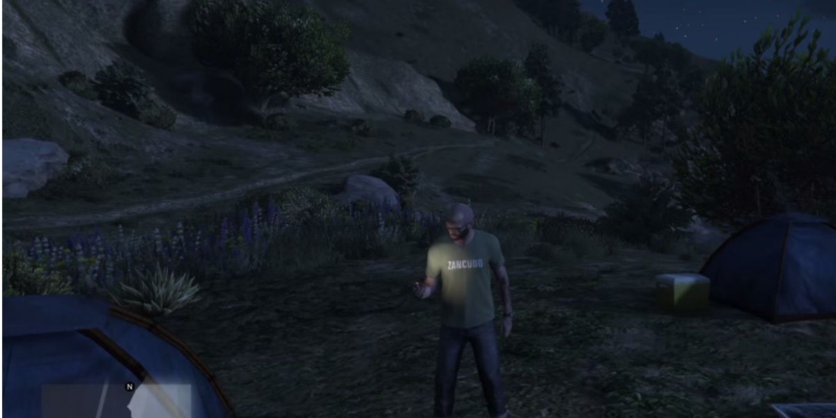 GTA 5 player looking at a phone on the seaside at night.