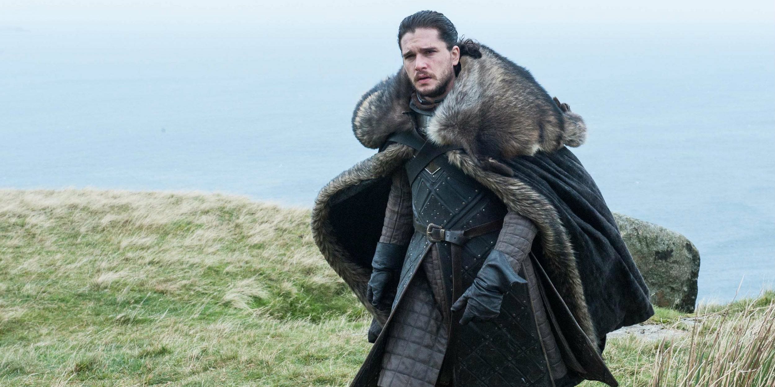Jon Snow walking atop a cliff in Game of Thrones.