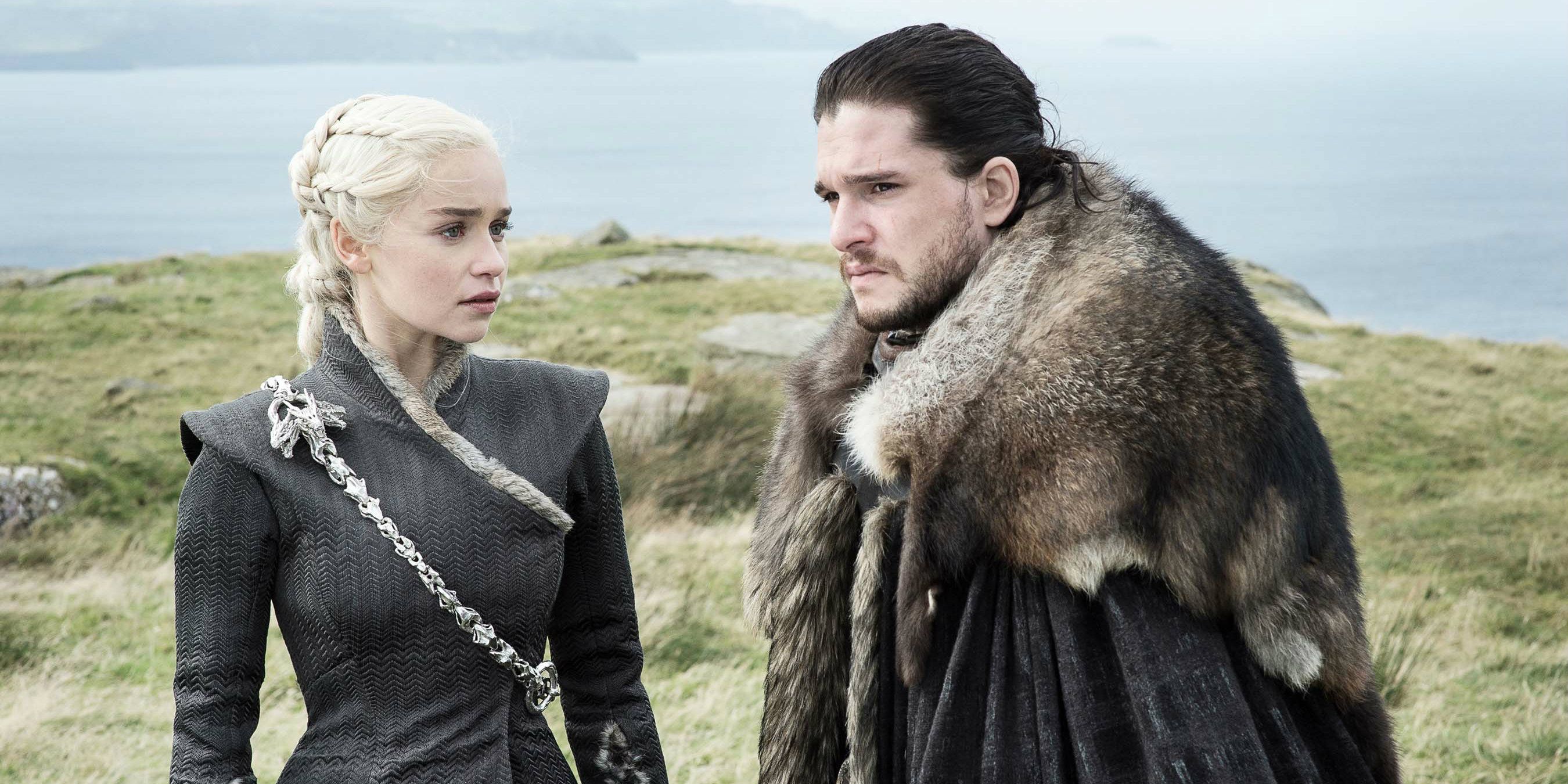 Daenerys Targaryen and Jon Snow looking serious, standing near water in Game of Thrones