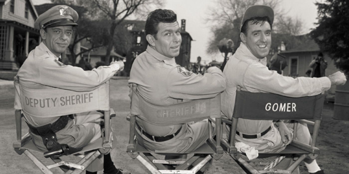 Don Knotts, Andy Griffith, and Jim Nabors sitting in directors chairs facing backwards on the set of The Andy Griffith Show