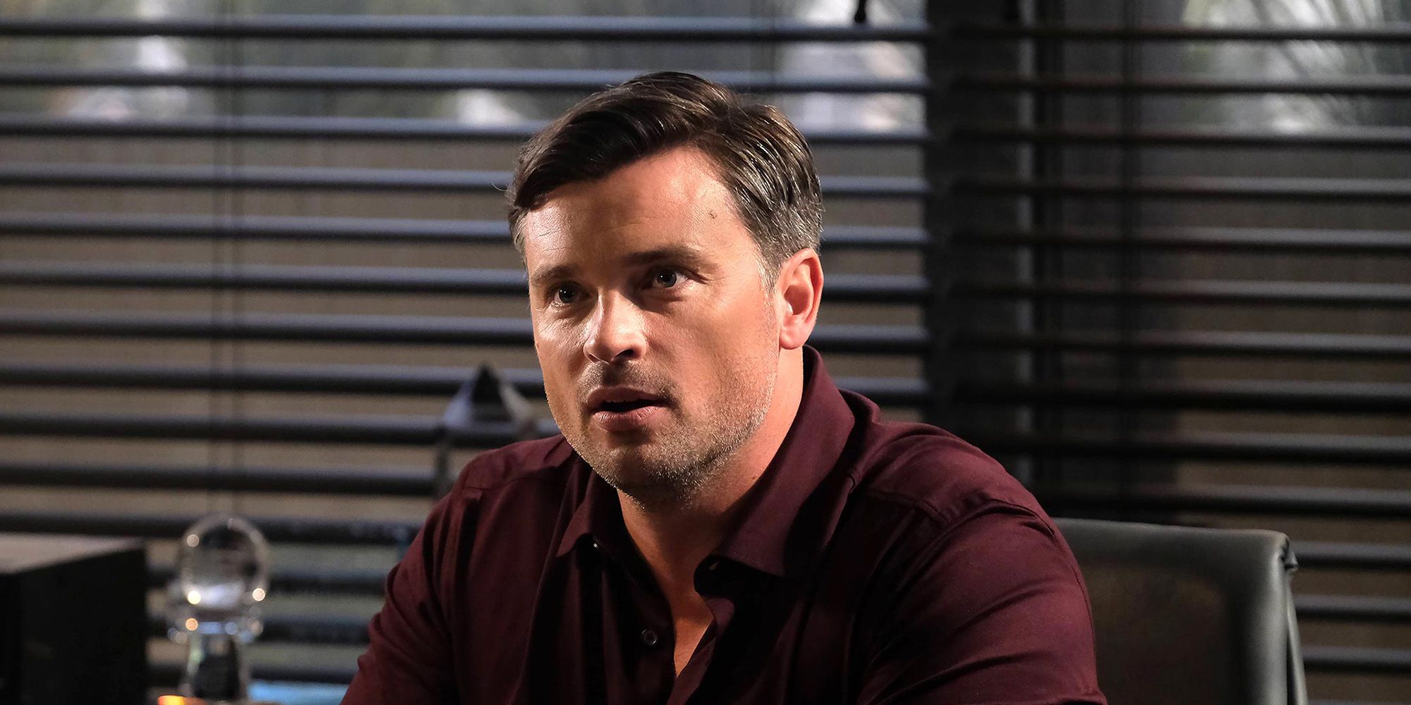 Tom Welling as Marcus Pierce sitting in an office in Lucifer