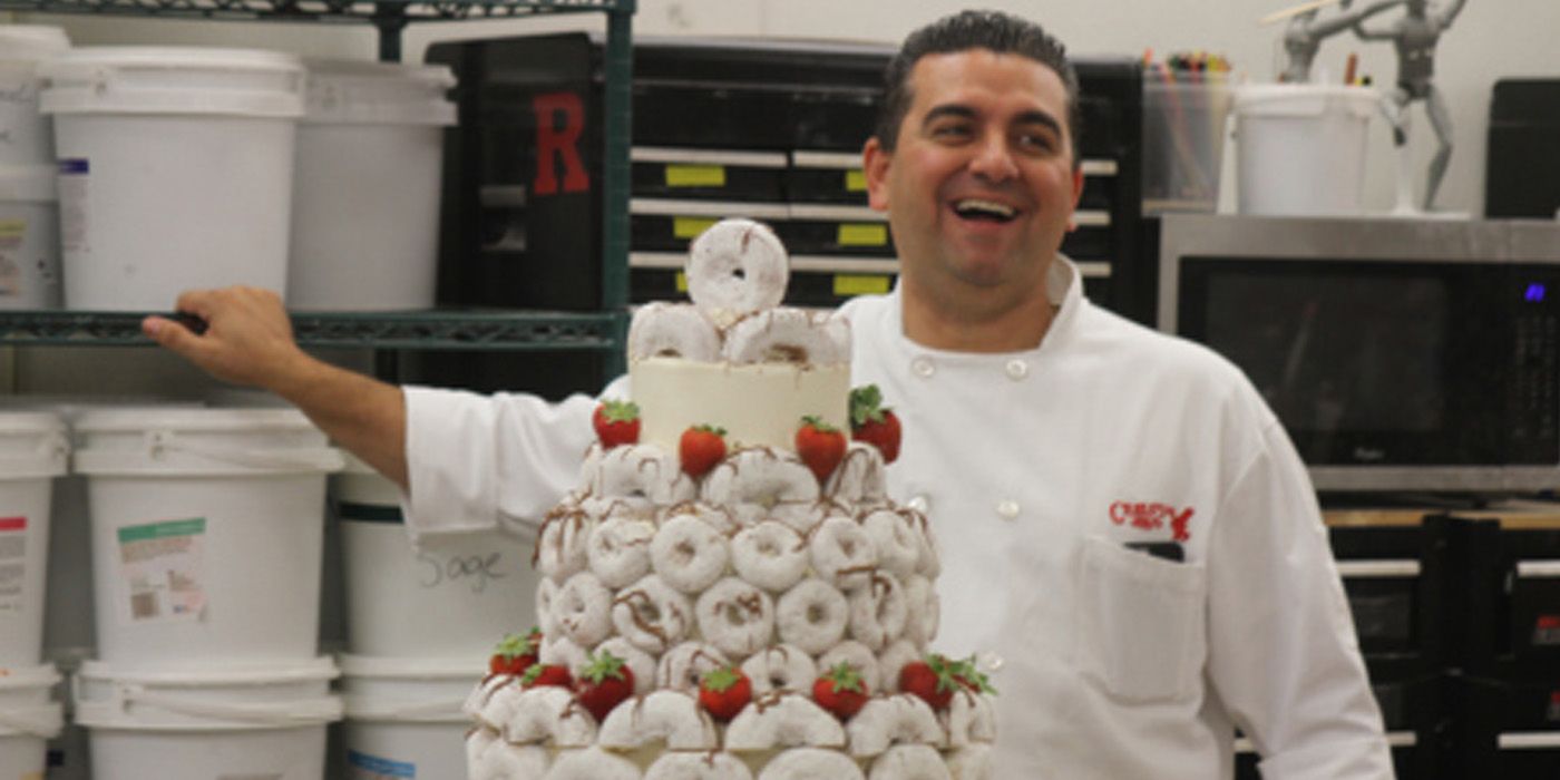 Buddy from Cake Boss posing with a cake