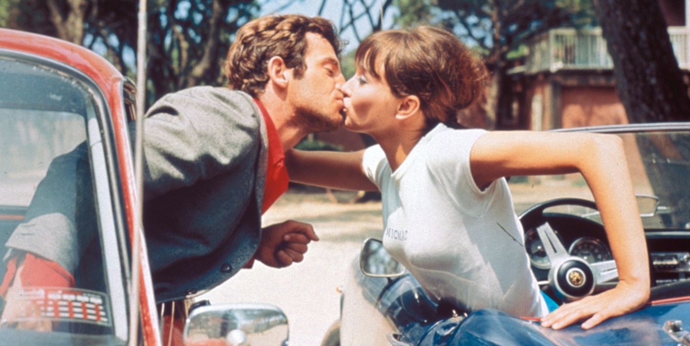 A shot of Ferdinand and Marianne leaning out of their cars to kiss in the movie Pierrot Le Fou.