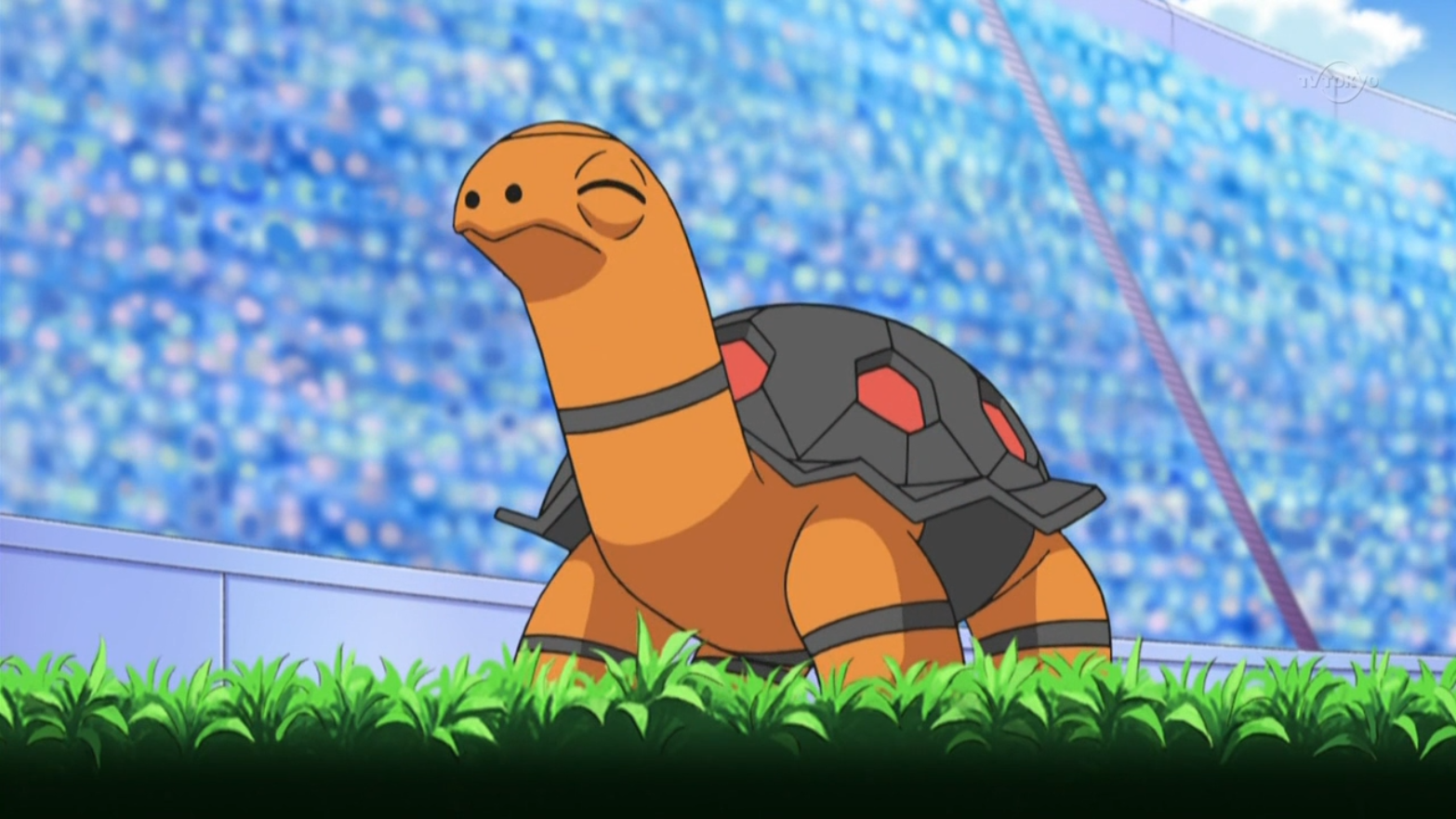 Torkoal stands on grass in the middle of a stadium in Pokémon.