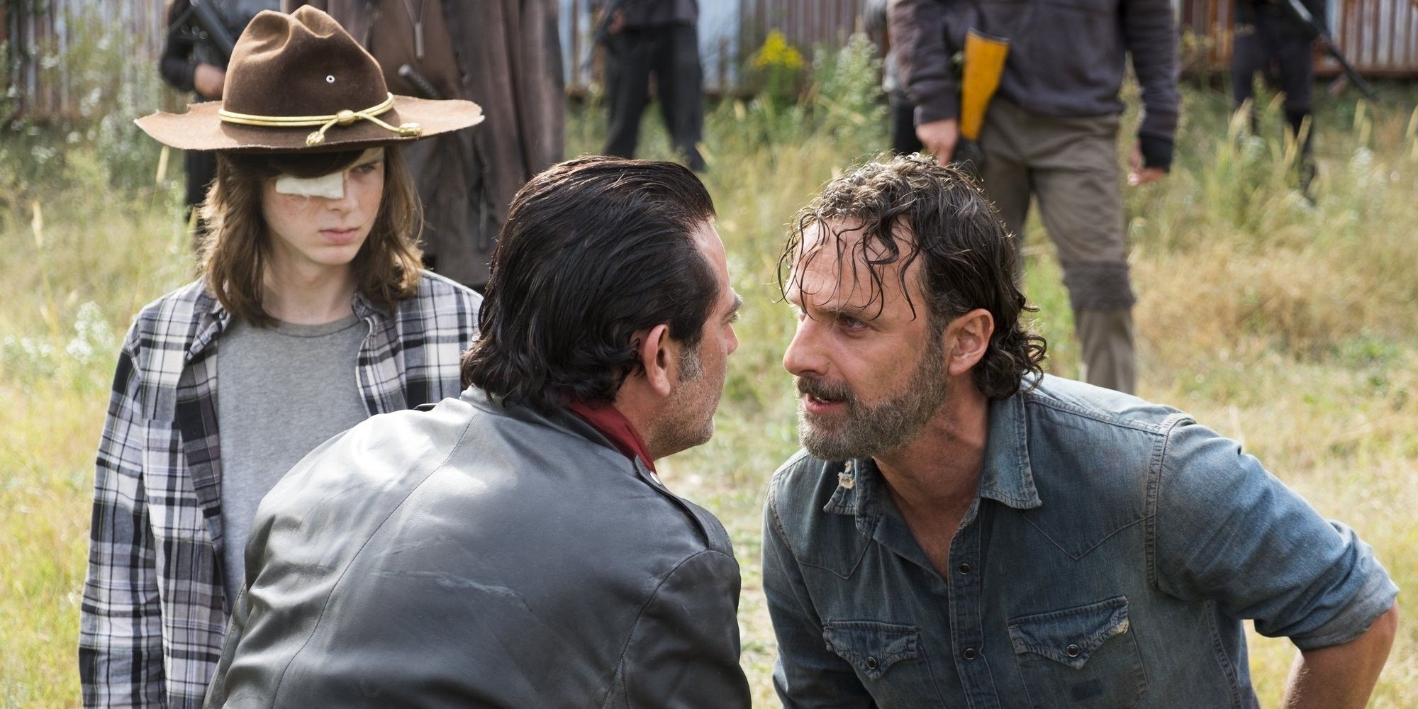 Rick Grimes and Negan in each other's faces as Carl watches in The Walking Dead