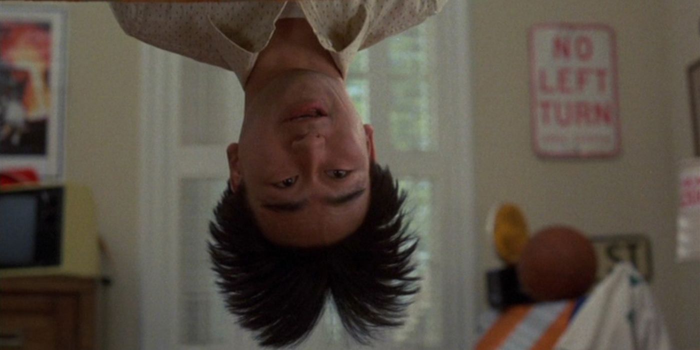 Gedde Watanabe as Long Duk Dong leans over the side of the bunkbed in Sixteen Candles