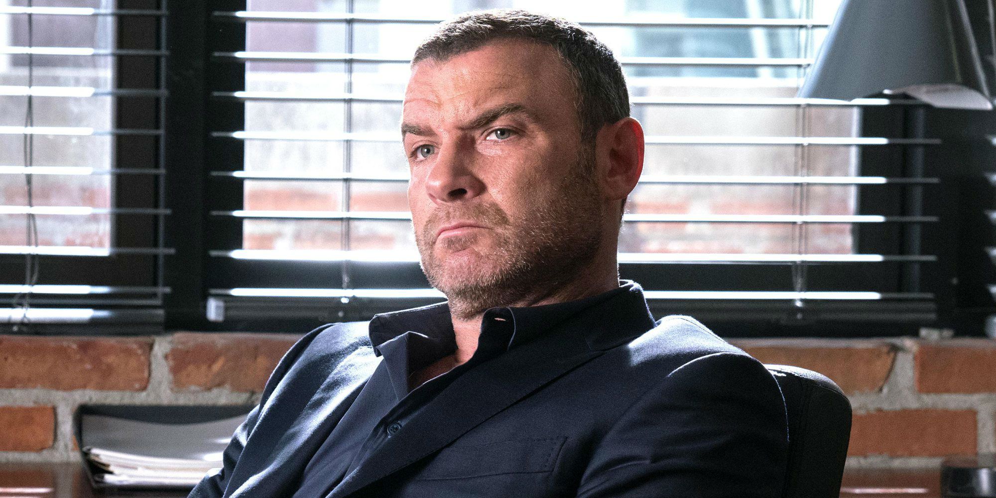 Ray Donovan sitting back on a chair