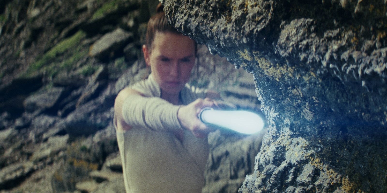 Rey pointing her lightsaber in The Last Jedi