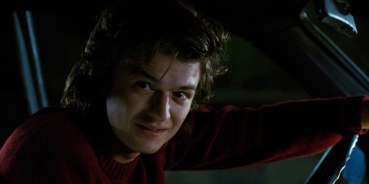Steve Harrington from Stranger Things Leans forward in his car to look out the window