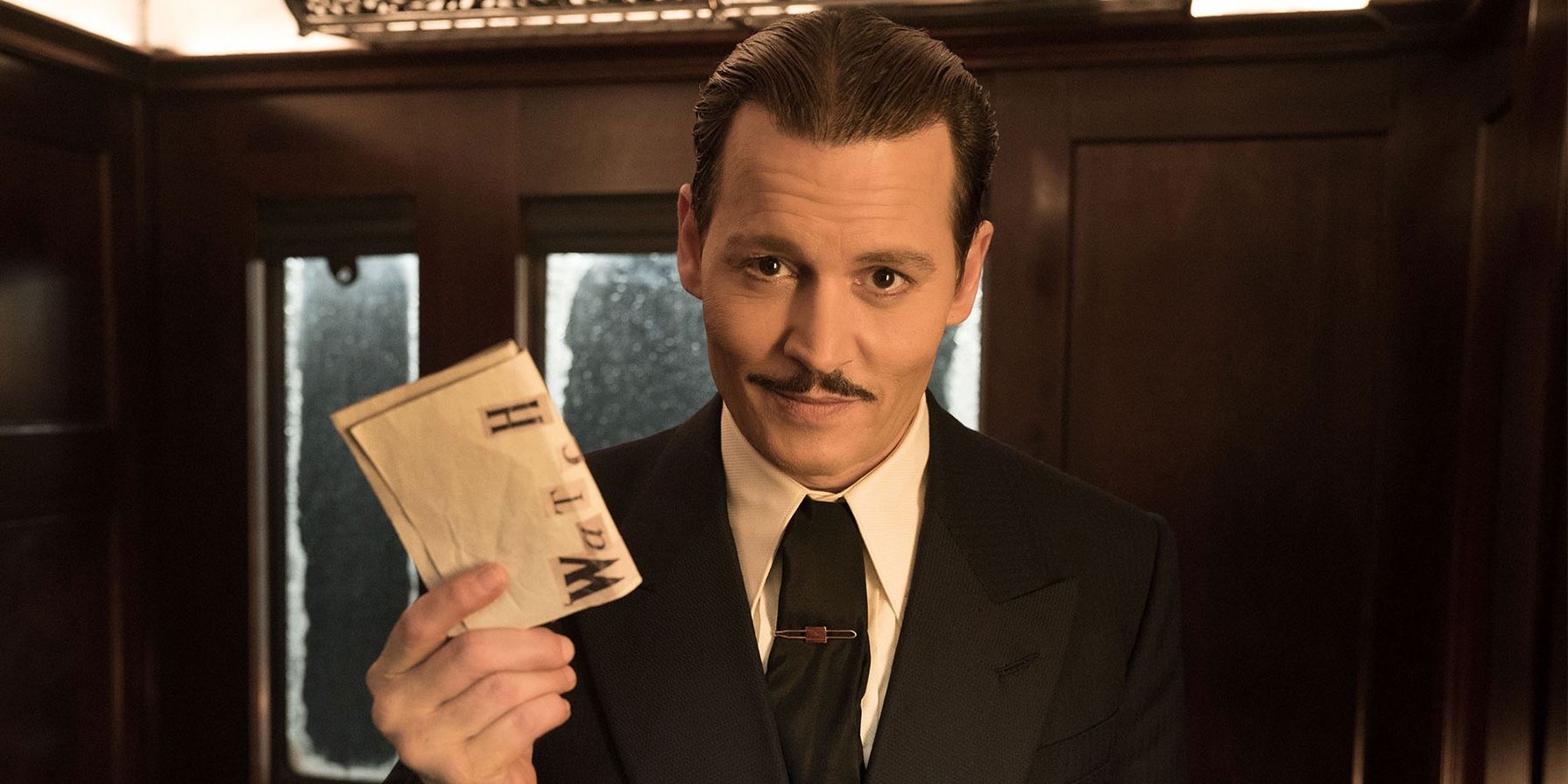Johnny Depp as edward ratchett holding a map in Murder on the Orient Express