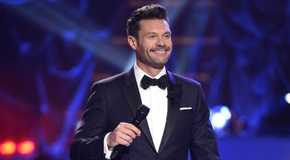 Ryan Seacrest hosting American Idol, holding a mic