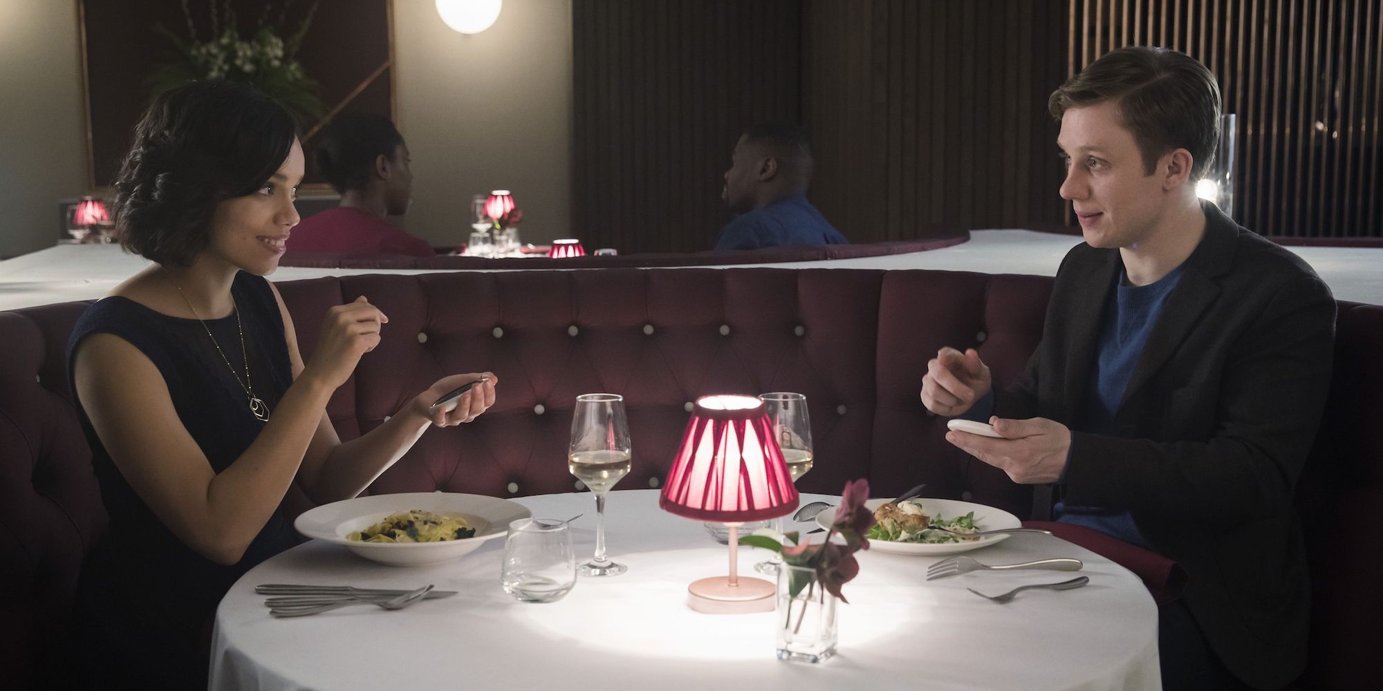 Georgina Campbell and Joe Cole sitting in a restaurant on a date in Black Mirror - Hang the DJ