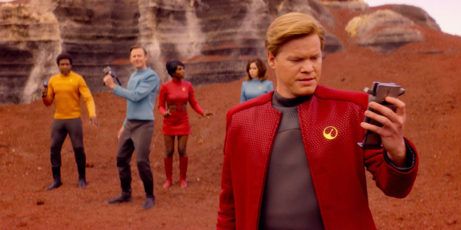 Jesse Plemons on a red planet, looking at a reader with his crew behind him in USS Callister Black Mirror